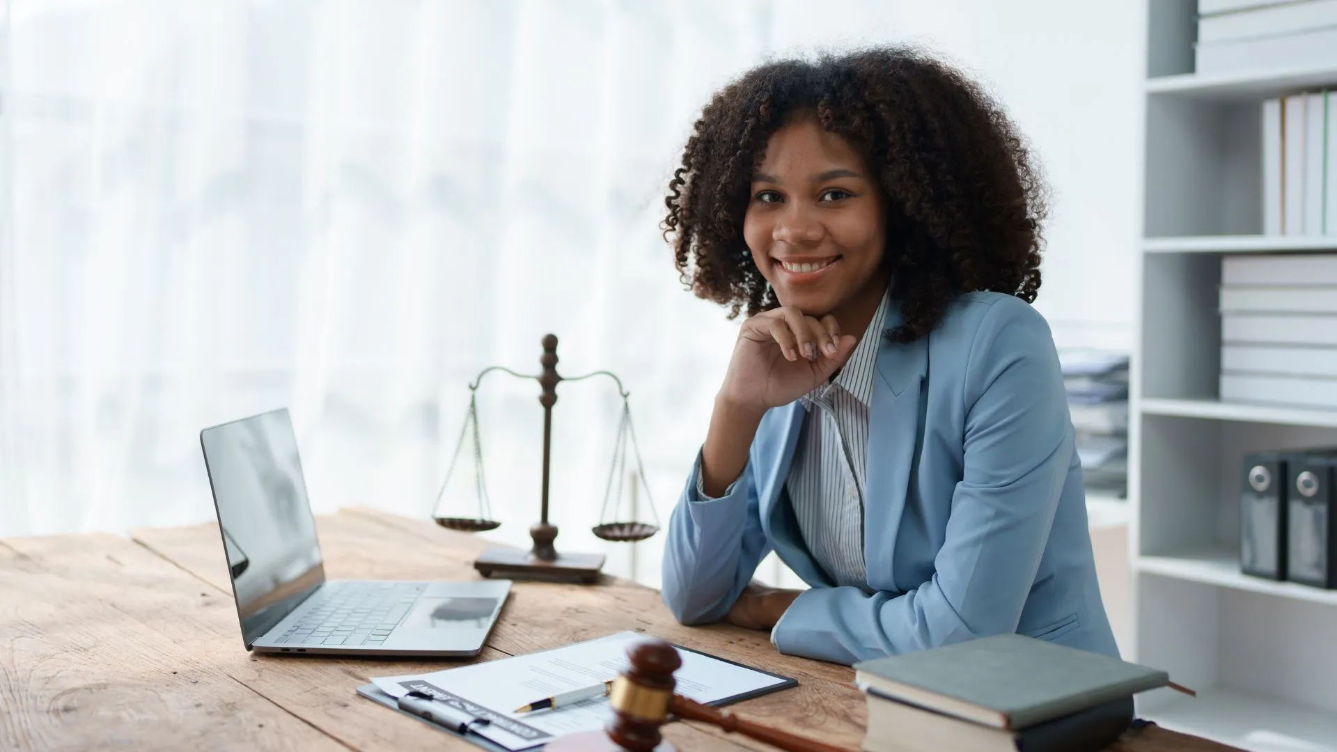 Female lawyer smiling with her laptop open while in her law office