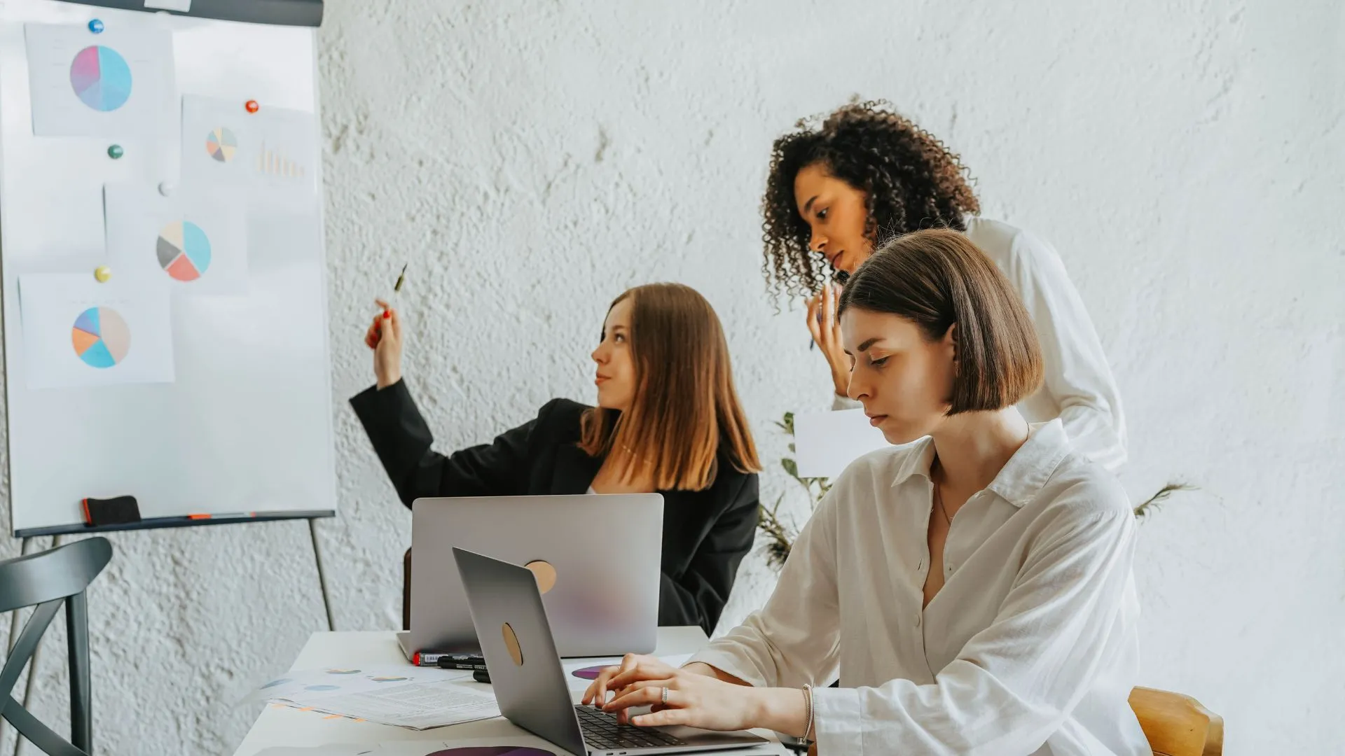 A three-woman team of marketing professionals discussing SAAS growth