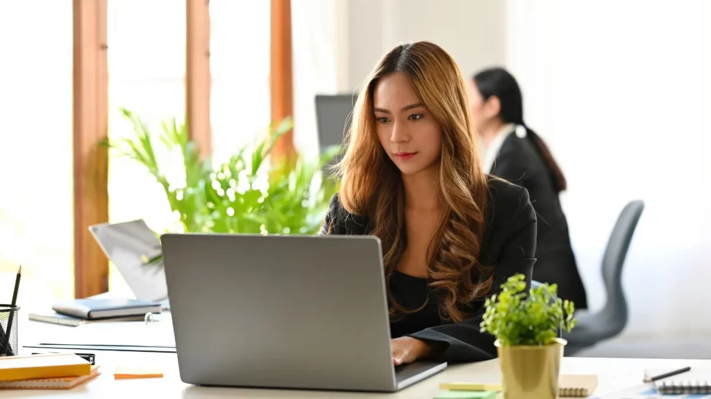 A marketing professional working intently on her laptop presumably on SAAS customer acquisition strategies