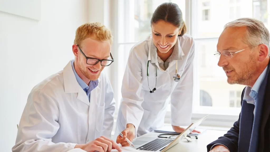 Three healthcare professionals discussing healthcare patient journeys