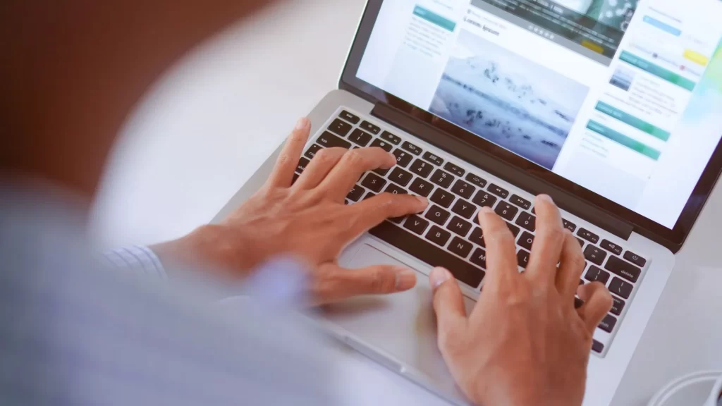 Hands typing on a laptop presumably working on content optimization